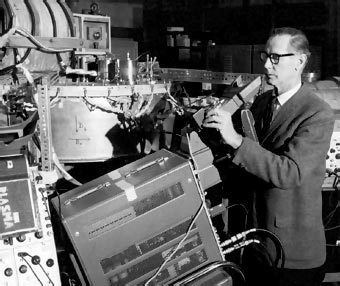 Black and white photo of a white man wearing glasses next to a vintage plasma device