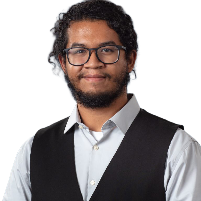 Headshot of a hispanic man with curly, dark hair and beard, wearing glasses